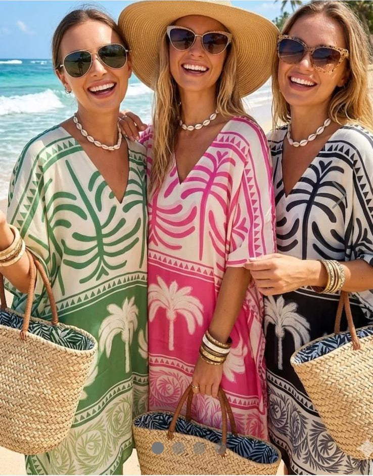 Three women wearing palm tree print silk cover-ups with a shopping app interface.